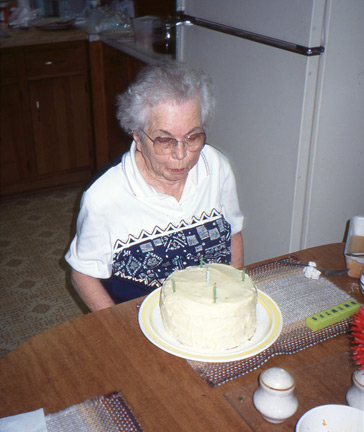 Mom a couple of years before she died with a birthday cake dotted with a few candles.