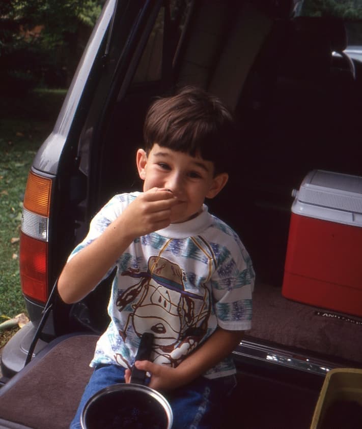 little boy eating blackberries